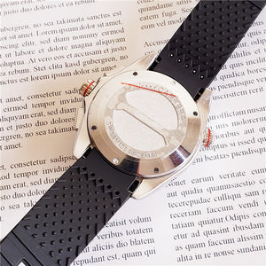 Mechanical Watches with a textured black rubber strap and polished silver case, showcasing intricate back design.